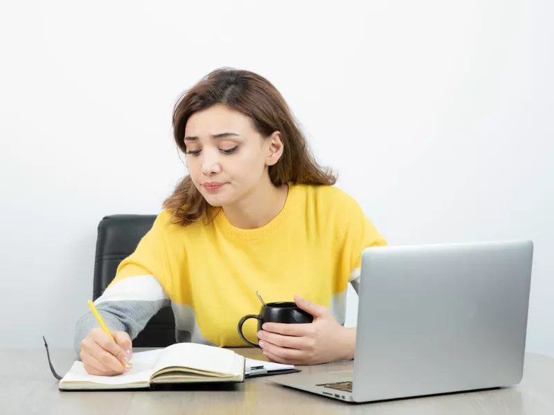 Student reviewing notes about online class help costs by subject and level<br />
